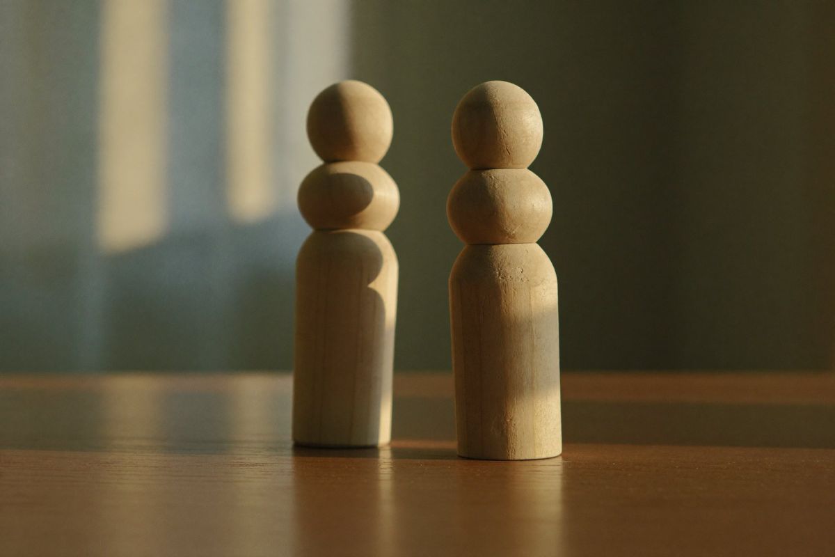 Zwei Holzfiguren im Abendlicht – Integration nach der Aufstellung